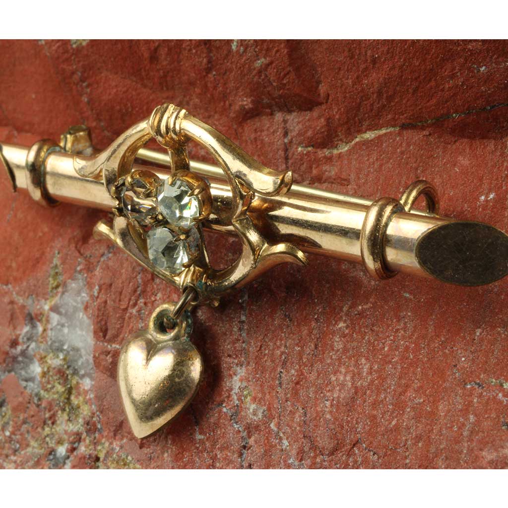 broche af forgyldt metal og guldblik elegant anrettet med tre stene og lille hjerte