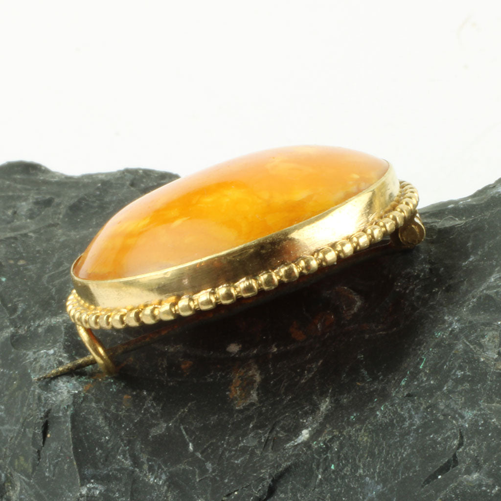 Broche af rav og forgyldt metal