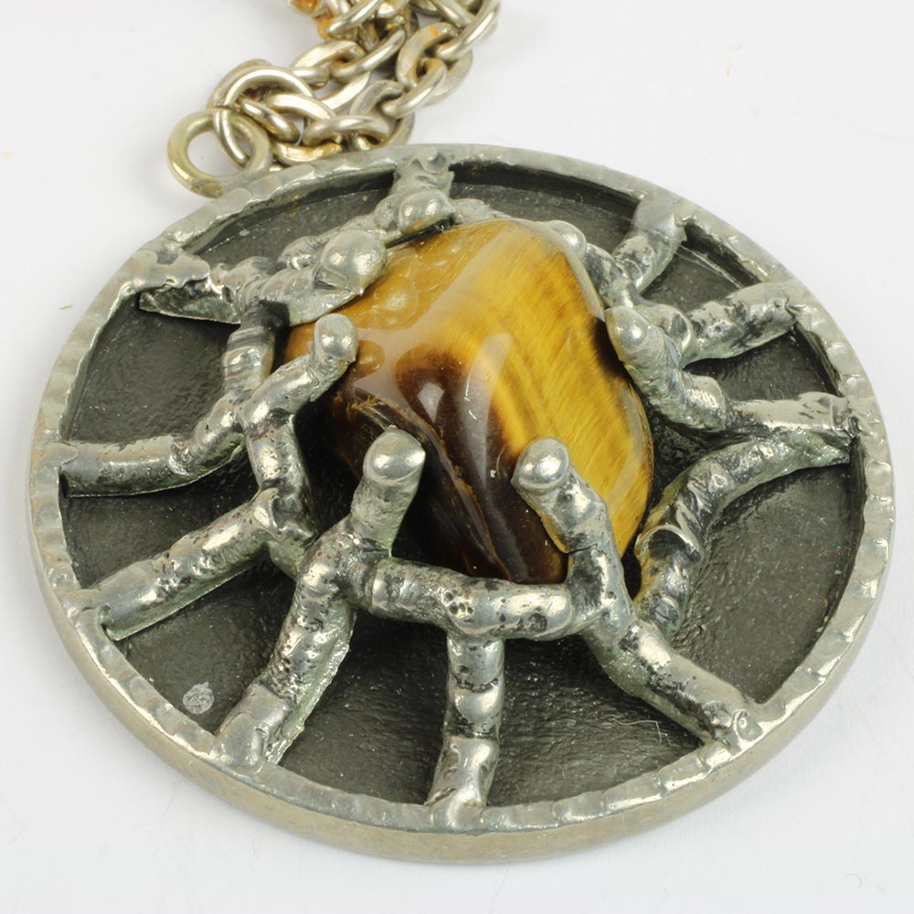 smykke med stort vedhæng i tin med i sat slebet tigerøje