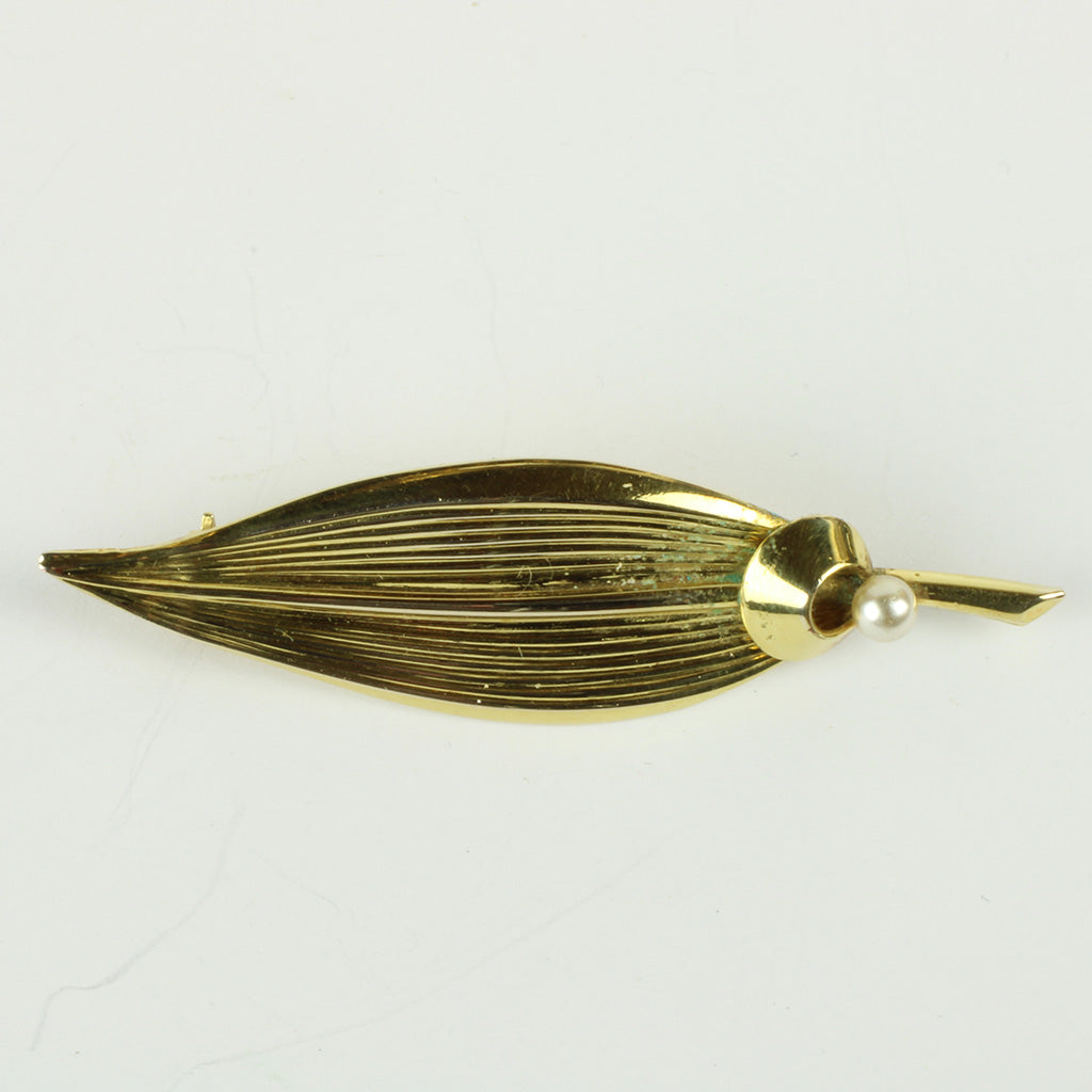 Broche af forgyldt metal forestillende blad med påsat perle