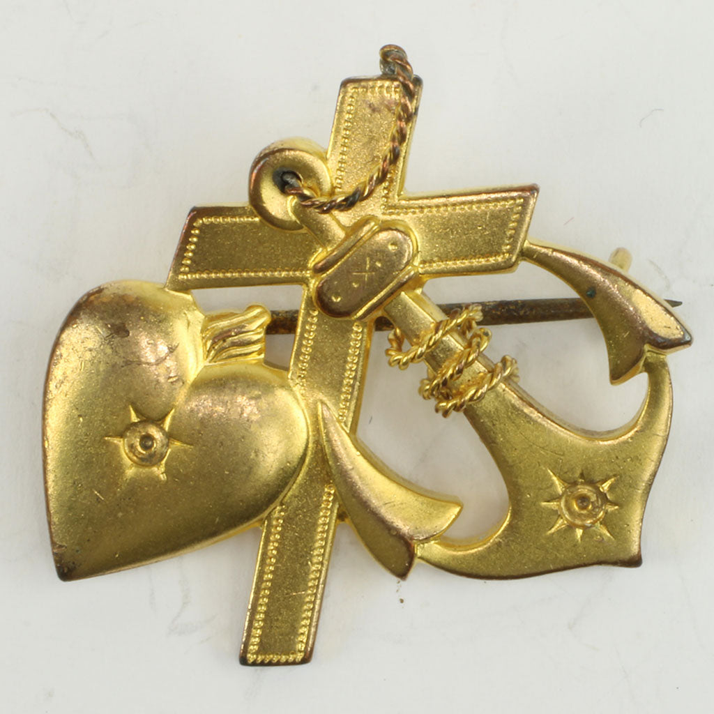 broche af forgyldt metal visende de tro symboler hjerte, kors og anker