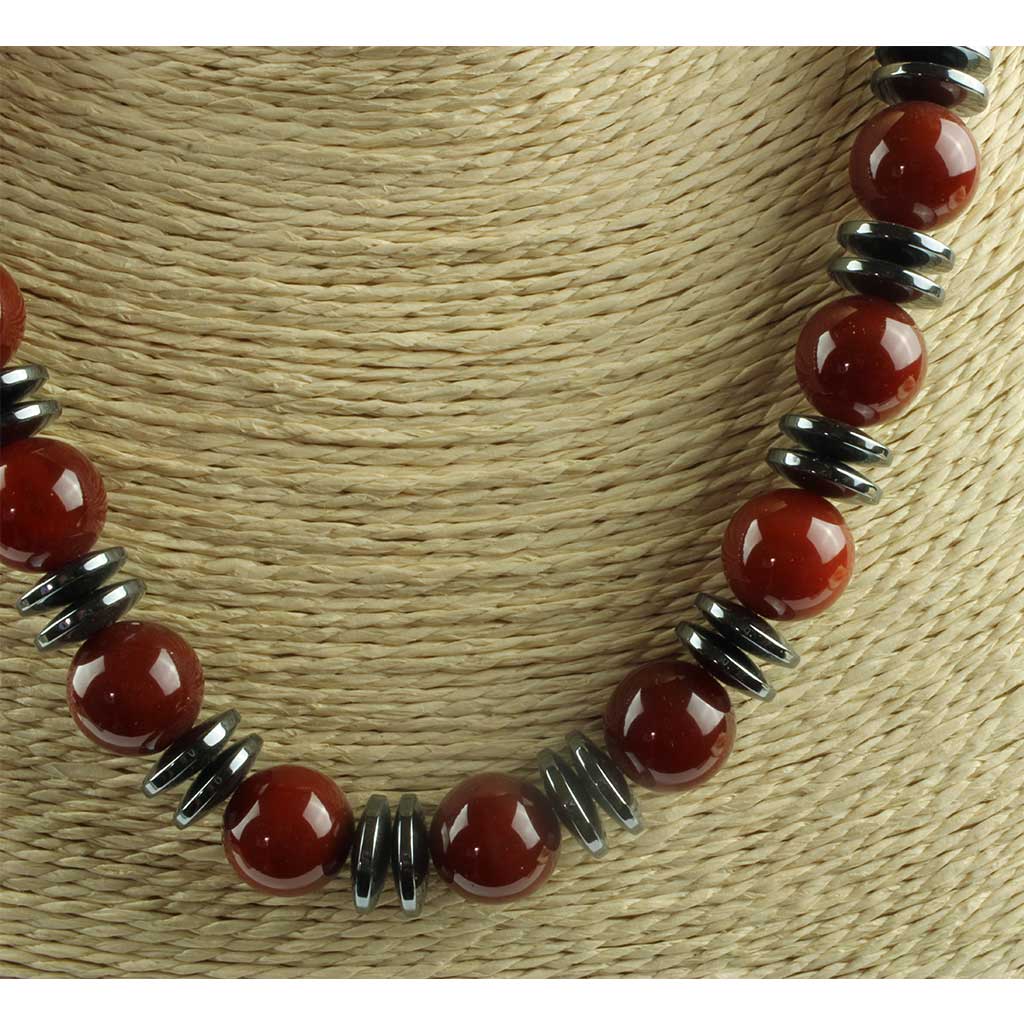 talrige flade perler antagelig hæmatit samt røde perler antagelig karneol.