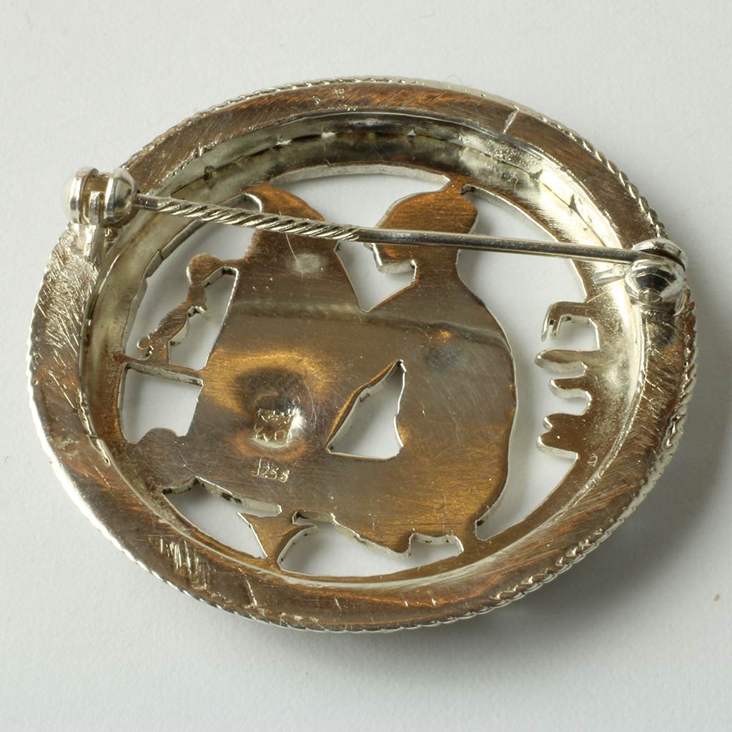 Broche af sølv med motiv af harpespiller