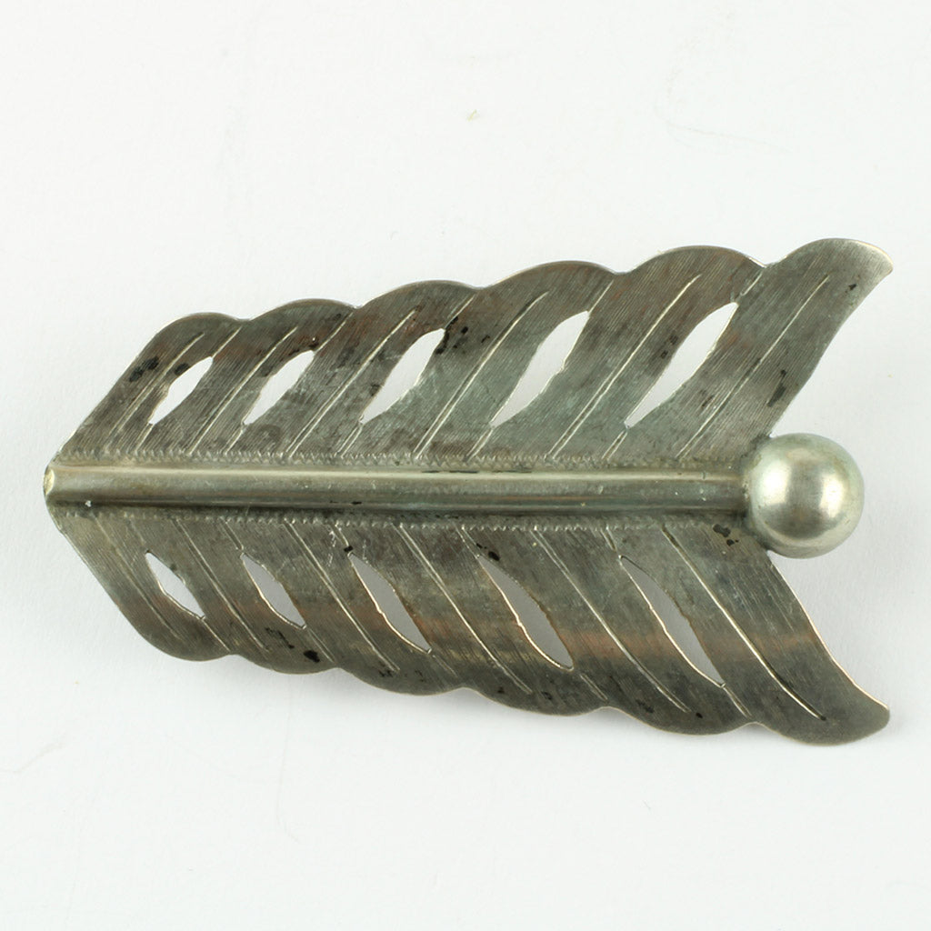 Broche af sølv fremstillet af den ene ende af en hårpil
