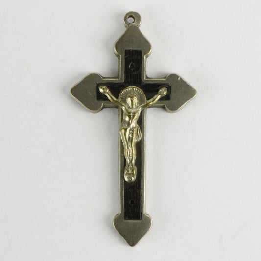 Lille krucifiks af hvidt metal der omkranser et kors