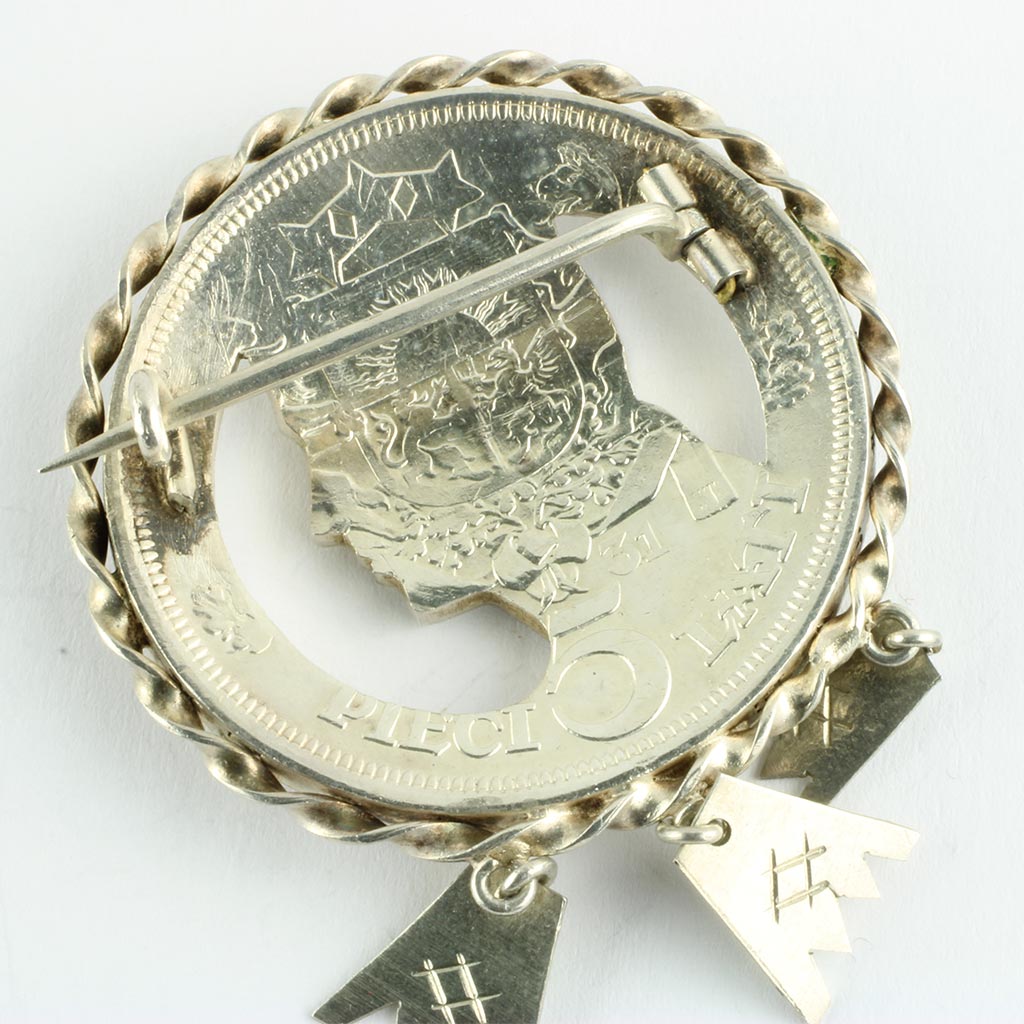 Mønten er monteret med forsnoet sølvkrans og tre sølvhænger